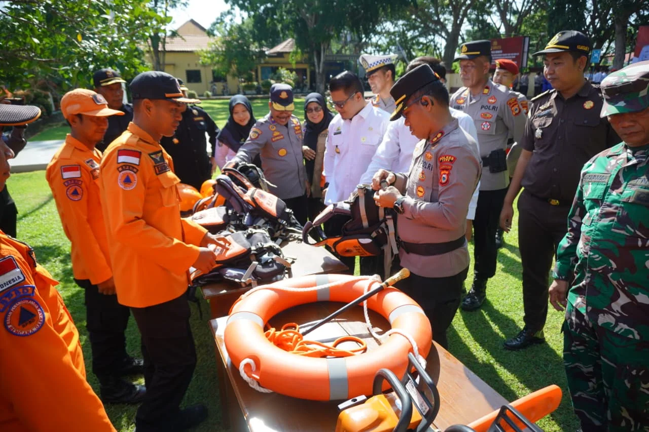 Pelatihan keselamatan dan perlengkapan tanggap darurat oleh polisi dan relawan di lapangan terbuka.