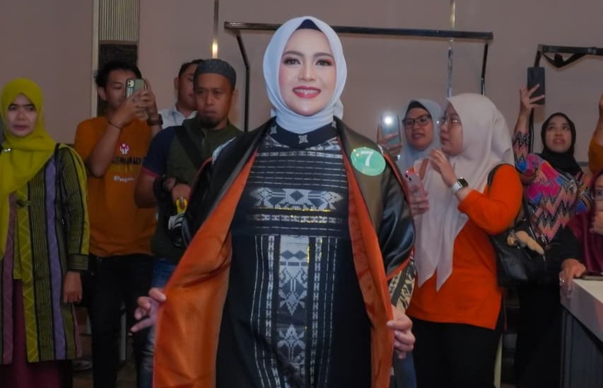Tampil anggun dalam acara pemilihan, wanita berhijab menunjukkan kepercayaan diri dan pesona budaya Indonesia.