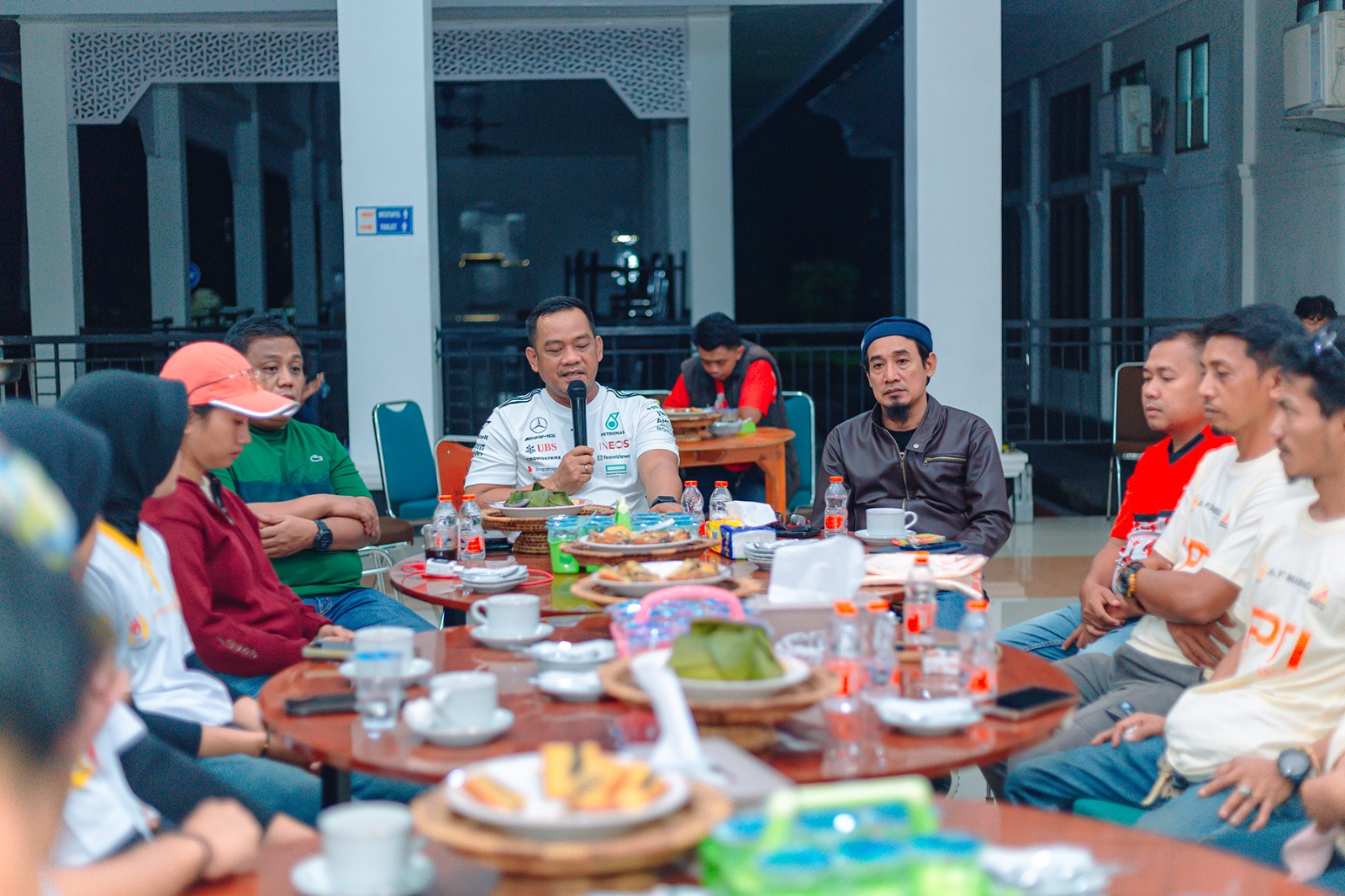 Makan bersama di acara komunitas motor di ruang terbuka.